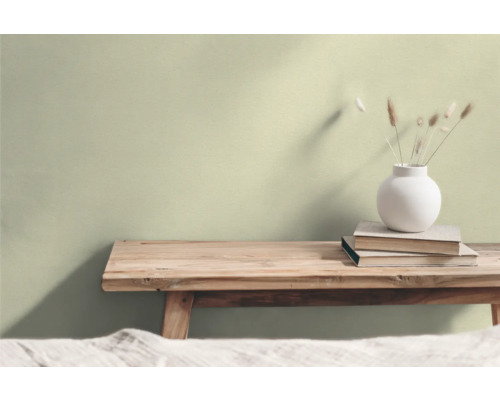 Woonkamer met houten kruk, stapel boeken en bloemenvaas