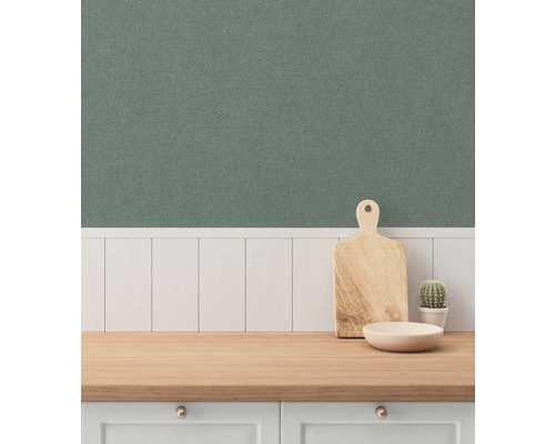 Keukenscène met houten snijplank, schaal en cactus op een aanrecht tegen een groene wandbekleding.