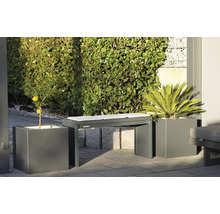 Tuinbank met kussens tussen plantenbakken met sierplanten