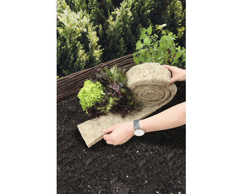 Moestuin met slaplanten en een rol plantenmat van natuurvezels op de grond.