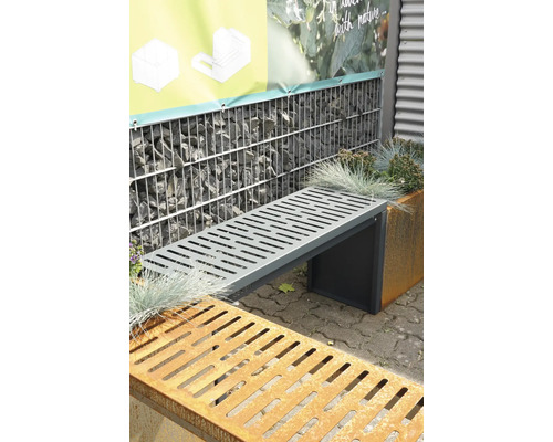 Grijze metalen tuinbank voor een schanskorfmuur en plantenbak