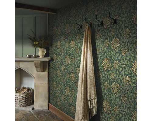 Gezellige kamer met bloemenbehang, open haard en deken aan de kapstok