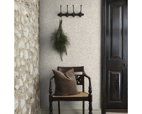 Hal met bloemenbehang, houten stoel, kussen, kapstok, deur en stenen muur