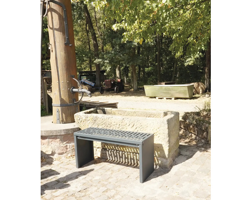 Buitenscène met een bank voor een stenen trog