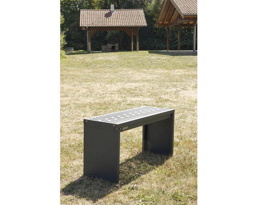 Grijze parkbank met lattenbodem en overkapping op de achtergrond