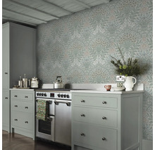 Keukenscène met bloemrijk behang, fornuis en grijze kasten