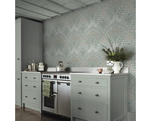 Keukenscène met bloemrijk behang, fornuis en grijze kasten