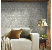 Woonkamer met bloemenbehang, bank, lamp en bijzettafel