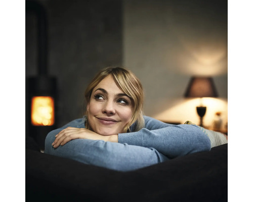 Vrouw ontspant op bank met kachel op de achtergrond