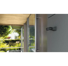 Buitenlamp aan een huismuur met uitzicht op de tuin