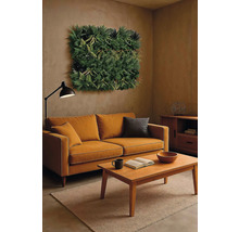 Woonkamer met bank, salontafel, vloerlamp en wandbegroening