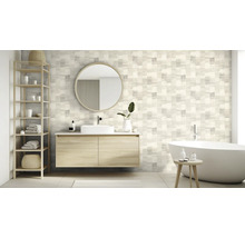 Badkamer met wastafel, spiegel, rek en bad voor een wand met vierkant patroon.