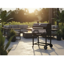 Tuinscene met houtskoolgrill, zithoek en vuurplaats voor een gezellige buitenambiance.