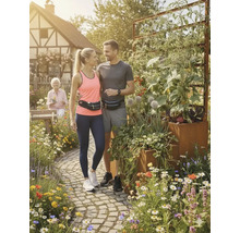 Koppel met heuptasjes staat in een tuin met een verhoogde border.