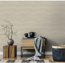 Woonkamer met beige behang in houtlook, houten kruk, commode, theepot en decoratie