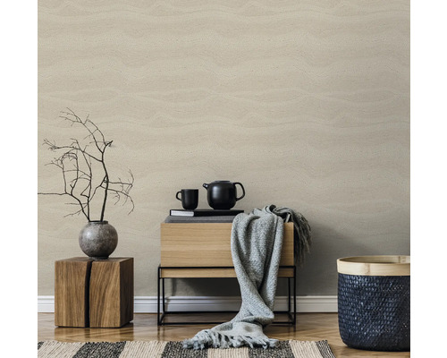 Woonkamer met beige behang in houtlook, houten kruk, commode, theepot en decoratie