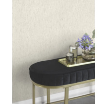 Scene met een gestructureerd behang, een zwarte bank met gouden frame, een gouden dienblad met kaarsen en een bloemenvaas.