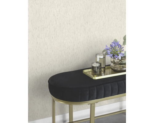 Scene met een gestructureerd behang, een zwarte bank met gouden frame, een gouden dienblad met kaarsen en een bloemenvaas.