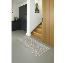 Interieurfoto van een modern ingerichte hal met een patroonteppich, een trap, een houten deur en een deel van een kitchenette.