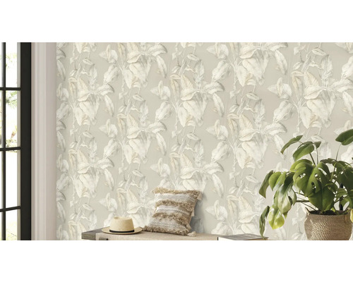 Woonkamer met een behang met plantenmotief, een kussen, een hoed en een kamerplant.