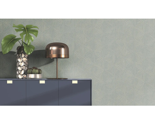 Wand met geometrisch behangpatroon, gedecoreerd met een tafellamp, potplanten en een kast