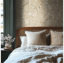 Slaapkamer met beige bloemenbehang en bed met kussens