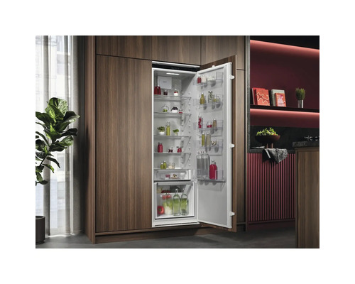 Geïntegreerde koelkast met open deur en levensmiddelen in een moderne keuken.