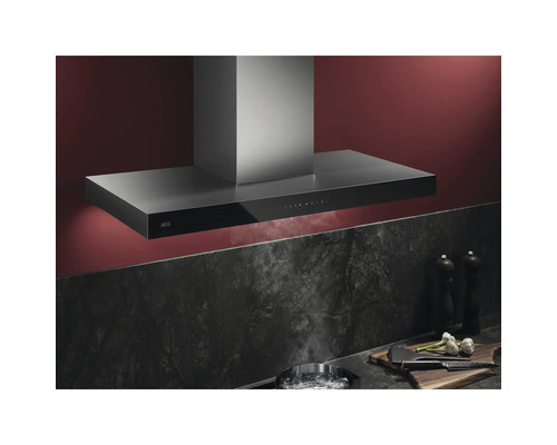 Roestvrijstalen wandafzuigkap boven kookplaat met stoom en ingrediënten