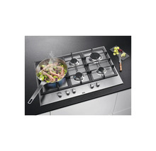 AEG gaskookplaat met vier kookzones, een pan met eten en fruit op een aanrecht