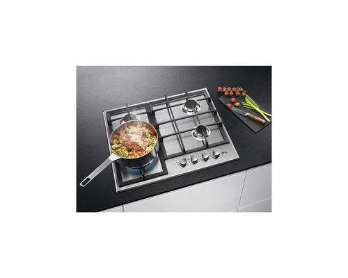 AEG gaskookplaat met pan, tomaten en prei op een aanrecht