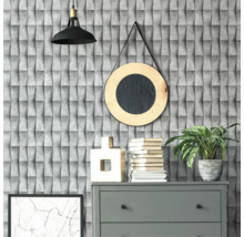 Decoratief interieur met grijze commode, boeken, kamerplant en ronde spiegel voor een gestructureerd behang