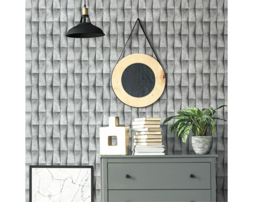 Decoratief interieur met grijze commode, boeken, kamerplant en ronde spiegel voor een gestructureerd behang