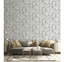 Woonkamer met bank, bijzettafels en behang met bamboepatroon voor een lichte en georganiseerde sfeer.