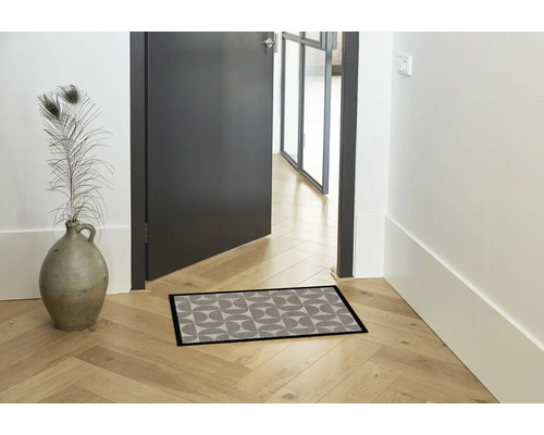 Hal met deurmat, vaas en geopende deur