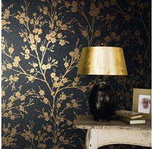 Close-up van een muur met donkerblauw bloemenbehang met een tafel, een lamp, boeken en een fotolijst