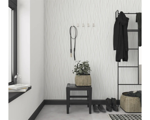 Entree met patroonbehang, kapstok en decoratieve elementen voor een georganiseerde en stijlvolle eerste indruk.