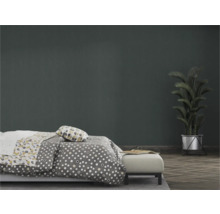 Slaapkamer met bed, beddengoed met print en kamerplant in pot