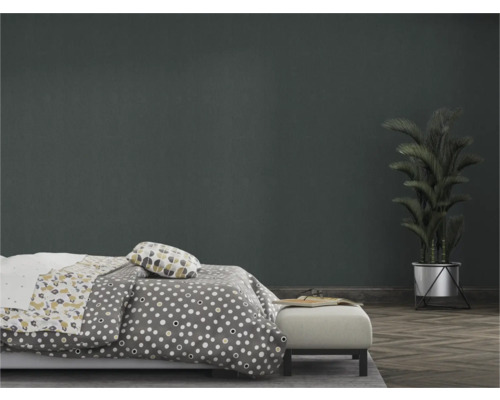 Slaapkamer met bed, beddengoed met print en kamerplant in pot