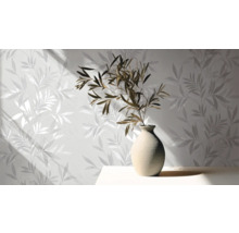 Lichte kamer met patroonbehang en vaas met takken op tafel