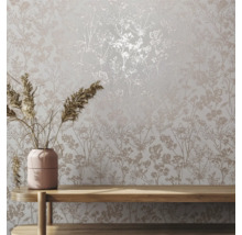 Close-up van een muur met bloemmotief behang en een houten tafel met bloemenvaas.