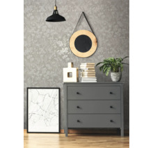 Decoratief interieur met patroonbehang, ladekast, spiegel, lamp en kamerplant