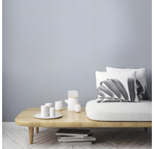 Woonkamer met houten tafel, servies en kussens met plantmotieven