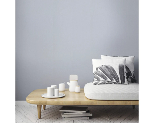 Woonkamer met houten tafel, servies en kussens met plantmotieven