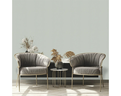 Woonkamer scène met twee fauteuils, een bijzettafel en decoratieve elementen op een dressoir