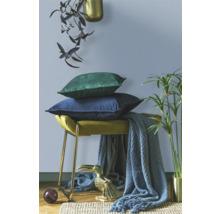 Decoratieve scène met krukken, kussens, dekens en decoratieve elementen voor de woonkamer.