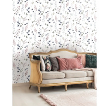 Woonkamer met bloemetjesbehang en bank