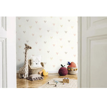 Kinderkamer met behang met hartjesmotief, knuffelgiraffe en decoratieve kussens