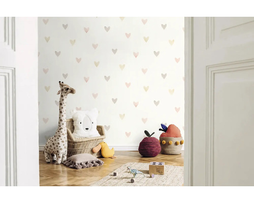 Kinderkamer met behang met hartjesmotief, knuffelgiraffe en decoratieve kussens