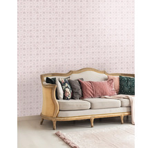 Decoratieve woonkamer met een bank en een behang met patroon met kronen en letters.