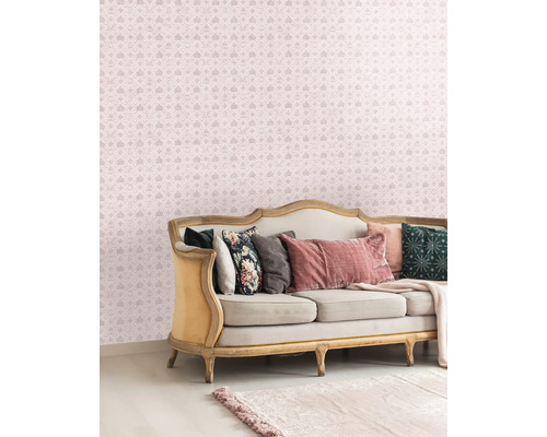 Decoratieve woonkamer met een bank en een behang met patroon met kronen en letters.